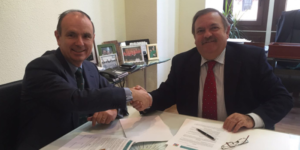 José Ortega, presidente de APADGE, y Javier Oyarzabal Latorre, de FAAD, estrechan las manos tras firmar un acuerdo de colaboración.