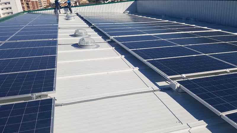 Trabajos de montaje de paneles solares fotovoltaicos sobre la cubierta de supermercado Deza en Córdoba, 