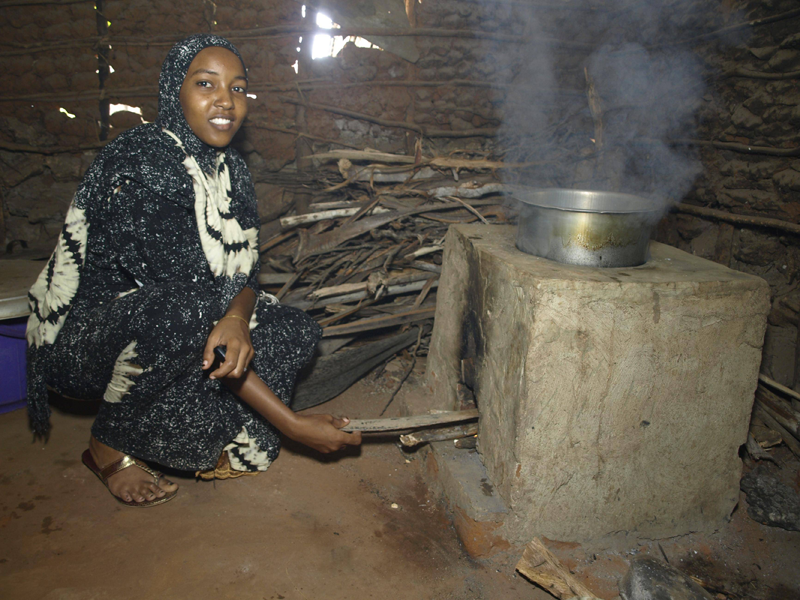 Mujer de Kenia ante un horno en el interior de su casa. Programa Carbon Zero de Toshiba en países en desarrollo. 