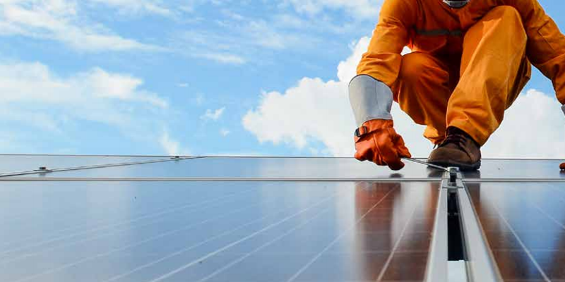 Operario trabajando sobre un panel fotovoltaico.