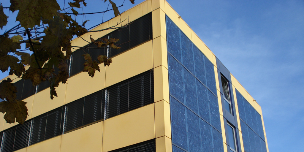 Fachada de un edificio residencial con instalación fotovoltaica para autoconsumo eléctrico compartido.