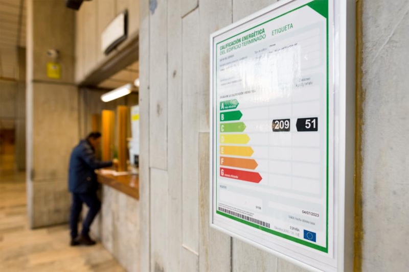 Primer plano de la etiqueta de calificación energética del edificio terminado instalada en el hall de acceso del MINETAD