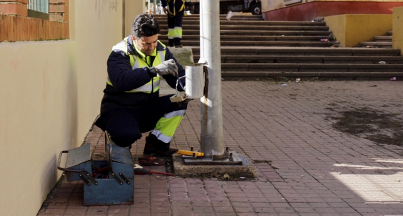 Operario del Ayuntamiento de Huelva realizando tareas de mantenimiento en una farola del alumbrado público. 