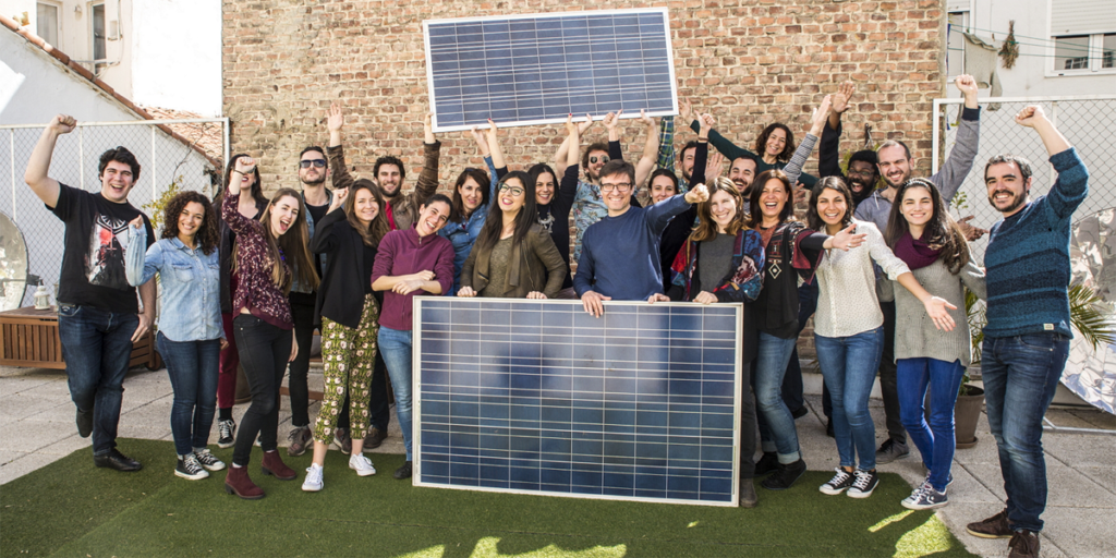 Segunda Oleada Solar de Ecooo. Un grupo de personas posa junto a placas fotovoltaicas.