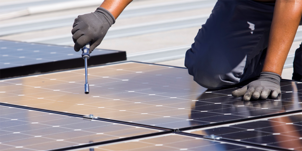 Profesional instalando placas de energía solar fotovoltaica.
