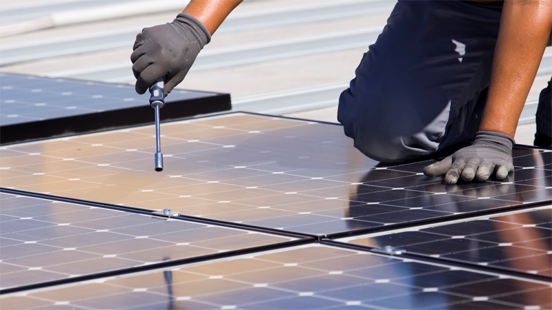Profesional instalando placas de energía solar fotovoltaica. 