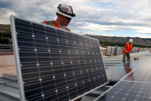 Profesionales instalando placas fotovoltaicas sobre la cubierta de un edificio.