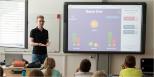 profesor dando clase en un aula y alumnos atendiendo desde su pupitre