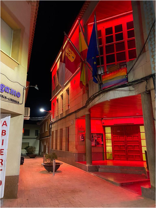 Entrada y fachada del Ayuntamiento de Villamalea (Albacete) iluminado con luces rojas.