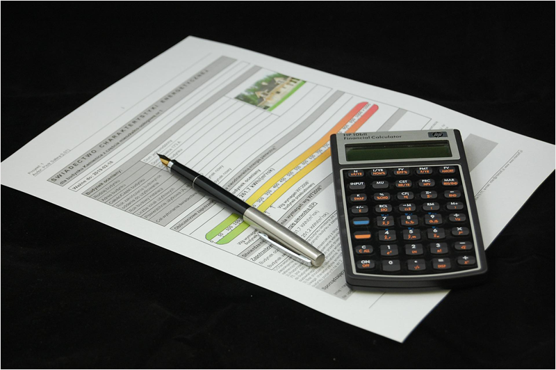 Calculadora, folio con unas gráficas y un bolígrafo.