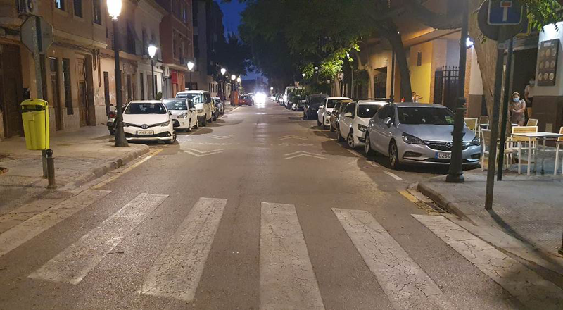 Nuevas farolas led en una calle de Valencia y una carretera con un paso de peatones y coches en los laterales de la vía.
