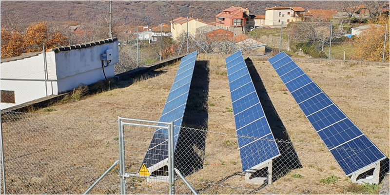 Placas solares instaladas en un terreno que está cercado con una valla.