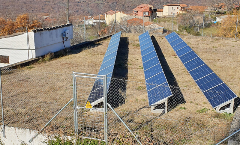 Placas solares instaladas en un terreno que está cercado con una valla.