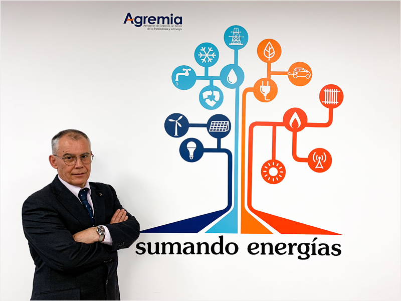 Presidente de Agremia, Emiliano Bernardo al lado de un árbol energético y la frase sumando energías.