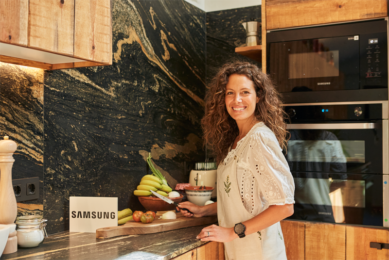 Presentadora Laura Madrueño en una cocina con electrodomésticos Samsung.