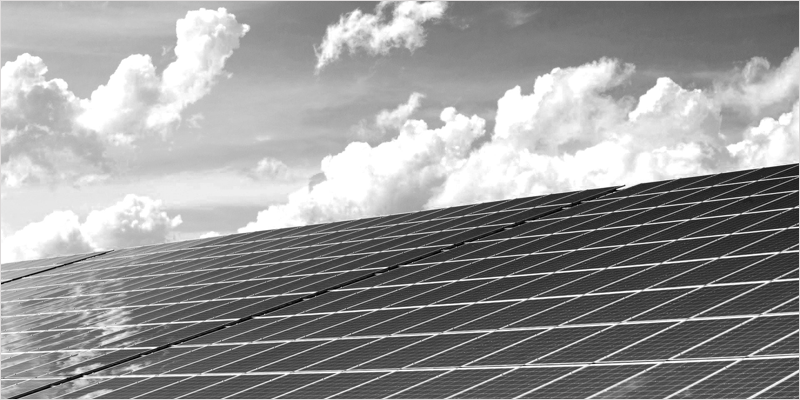 Paneles solares instalados, nubes y cielo al fondo. Imagen en blanco y negro.