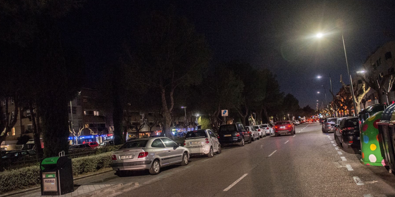 Calle de noche en Pozuelo de Alarcón con vehículos aparcados a ambos lados.