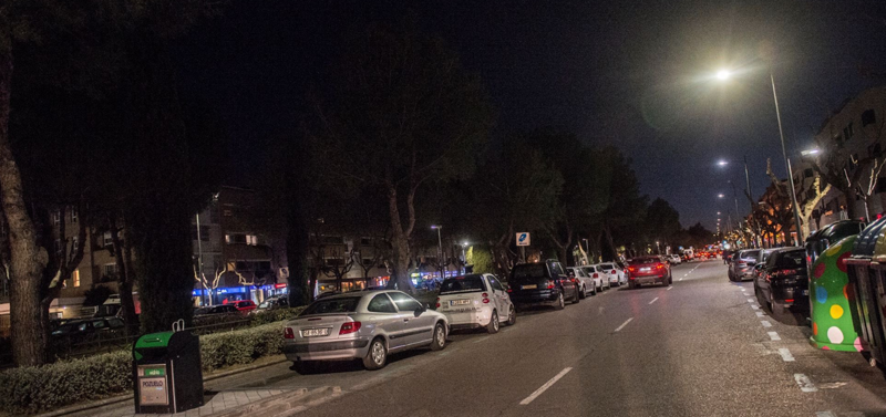 Calle de noche en Pozuelo de Alarcón con vehículos aparcados a ambos lados.