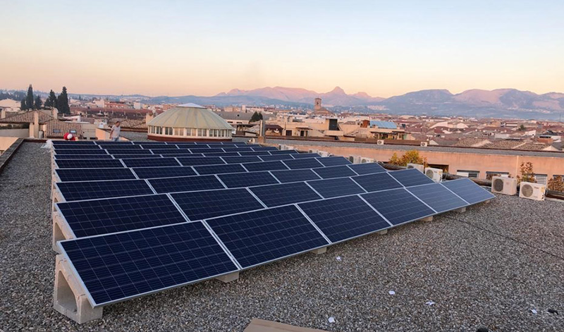 Instalación de paneles solares fotovoltaicos en el tejado de un colegio.