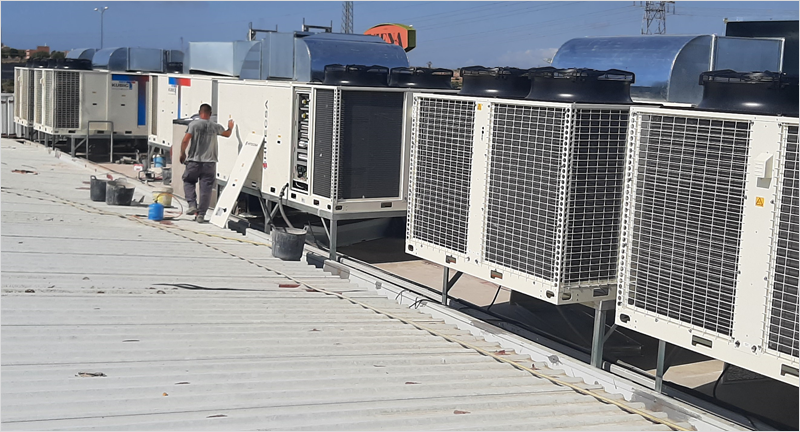 Seis rooftop aire aire del modelo kunbi 55 de Hitecsa instalados en el tejado de una tienda.