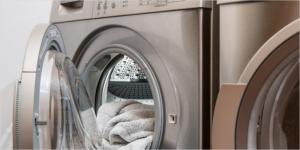 Lavadora abierta con una toalla.