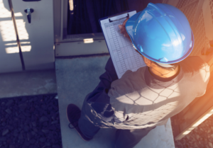 Hombre con casco apuntando datos.