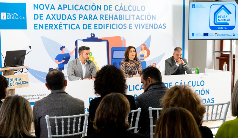 Presentación con una mujer y dos hombres en la mesa y público asistente en las sillas.