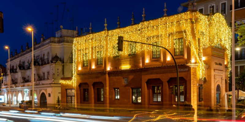 Fachada de un edificio iluminado con luces amarillas en Navidad.