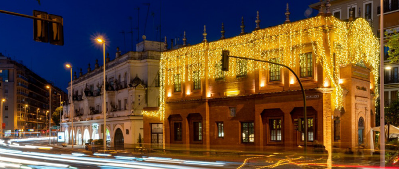Fachada de un edificio iluminado con luces amarillas en Navidad.