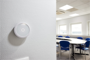 Sistema de control de iluminación instalado en una pared y las luces del techo encendidas.