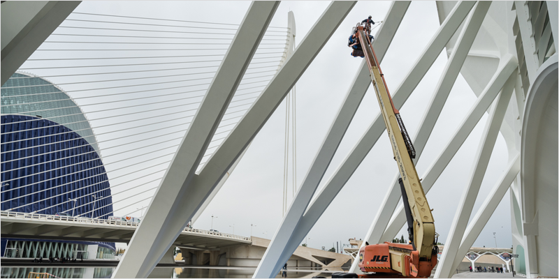 Exteriores de la Ciudad de las Artes y las Ciencias y una grua con un operario trabajando.