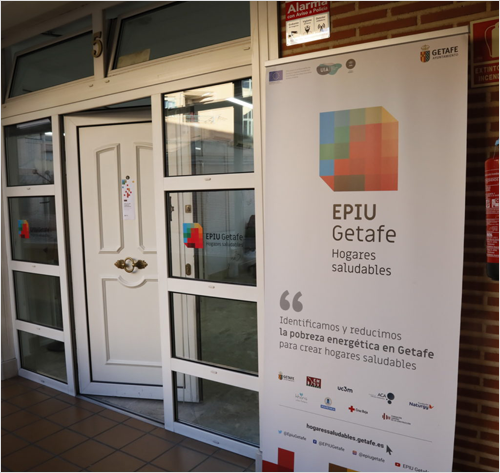 Puerta blanca abierta y en la entrada un cartel de EPIU Getafe.