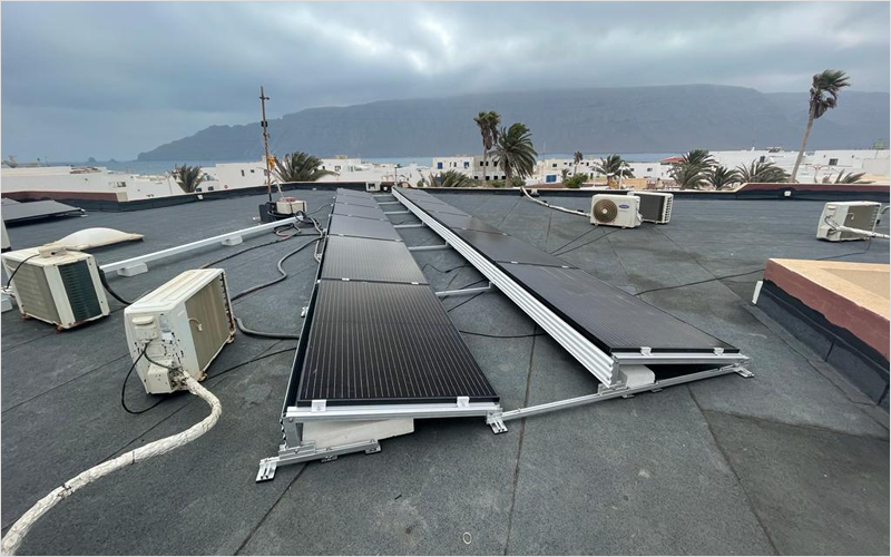 Placas solares y equipos de climatización instalados en la azotea de un edificio.