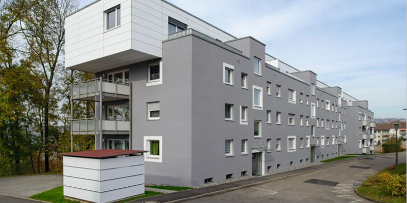 Infografía de un edificio de viviendas de varias alturas en color gris y blanco.