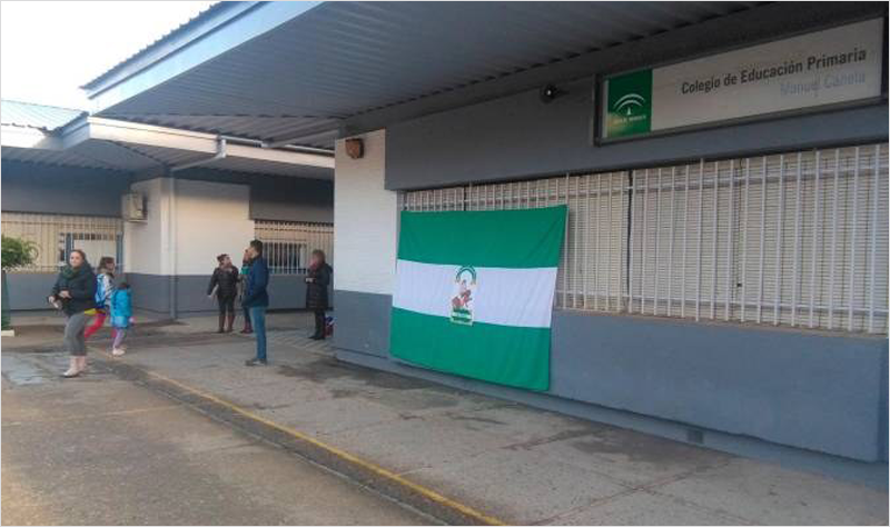 Entrada a un colegio de educación primaria de Andalucía con la bandera de Andalucía colgada.