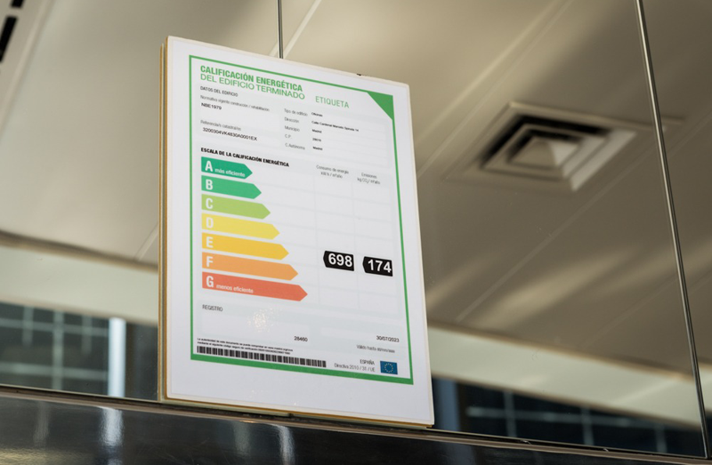 Certificado de calificación energética del edificio terminado colgado de una pared de la vivienda.