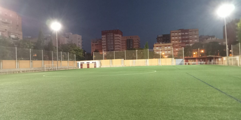 Campo de fútbol con césped e iluminación.