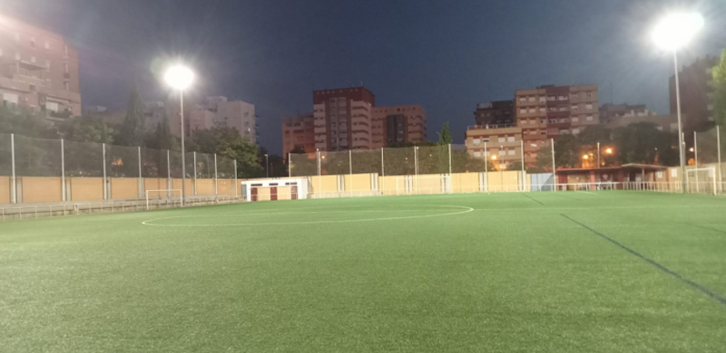 Campo de fútbol con césped e iluminación.