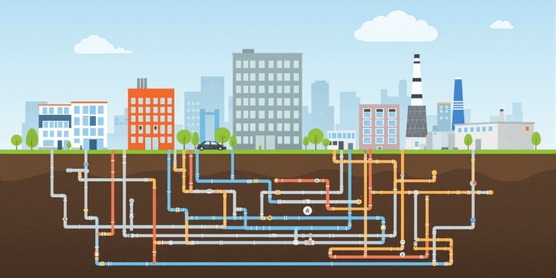 Imagen de una red de calefacción urbana con tuberías subterráneas que conectan edificios residenciales e industriales.